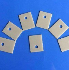 Aluminum nitride thermal insulating pads with mounting holes for TO-package transistors