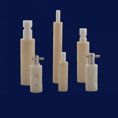 Stepped alumina ceramic insulators, some assembled with metal pins
